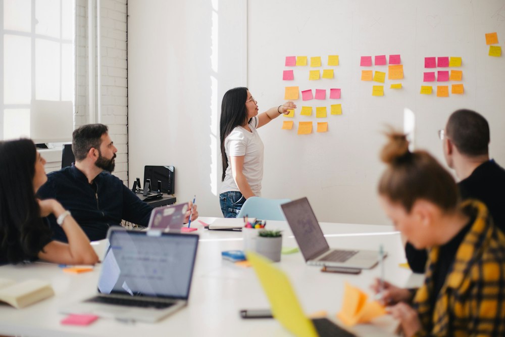 A product team planning work together around a board of sticky notes